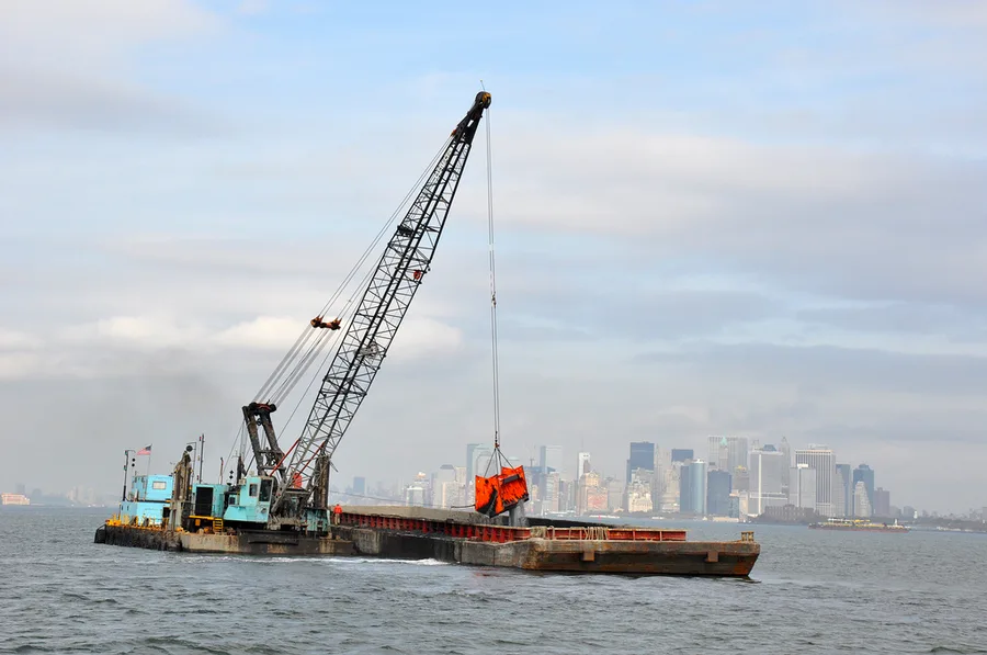 Kapal keruk clamshell bekerja di Anchorage Channel, Pelabuhan New York dan New Jersey
