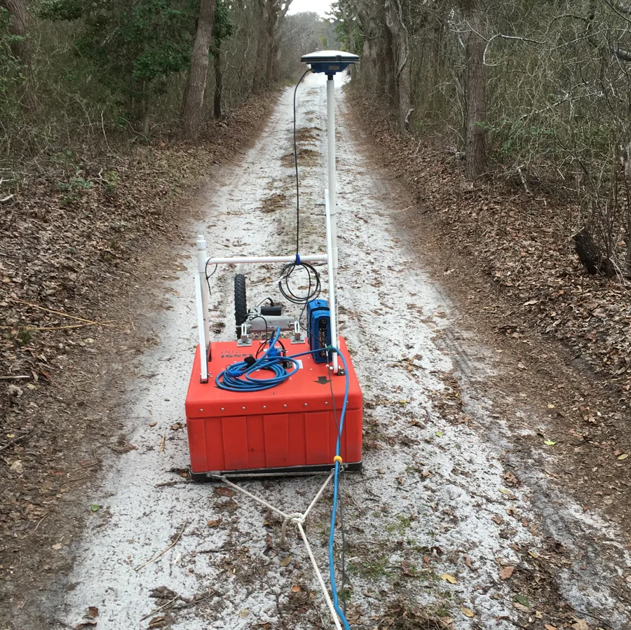 Peralatan ground-penetrating radar ditarik di belakang bukit pasir di Fire Island, New York