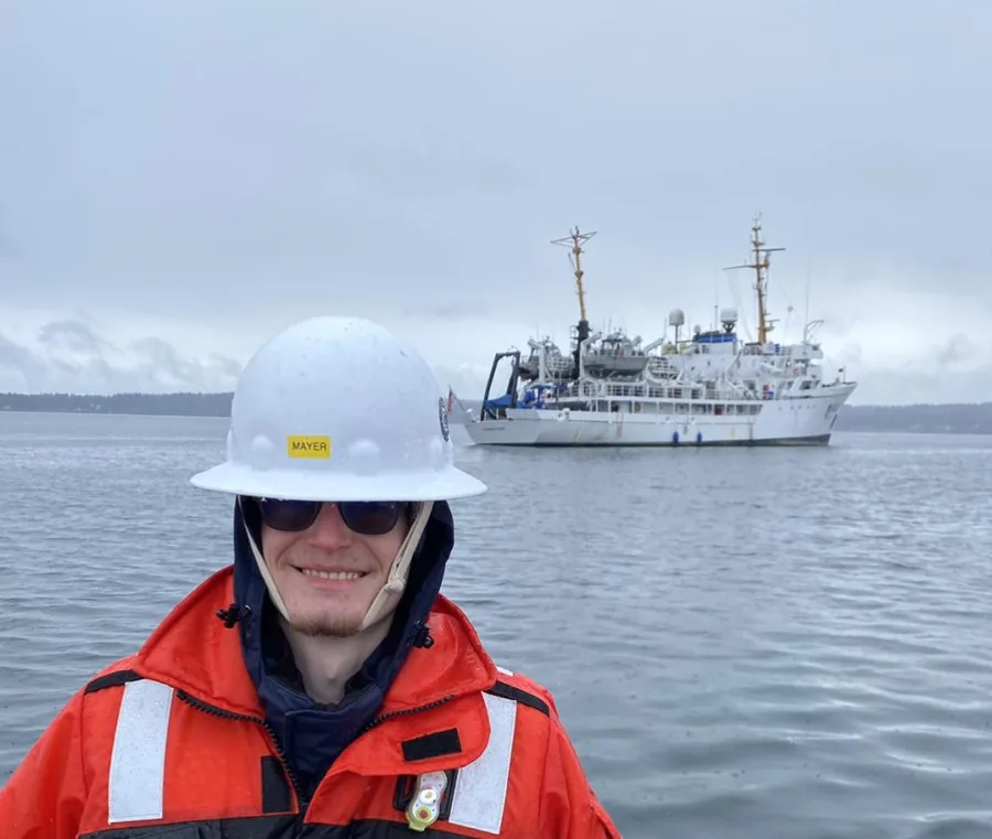 Seorang teknisi survei hidrografi senior NOAA berdiri di depan kapal survei