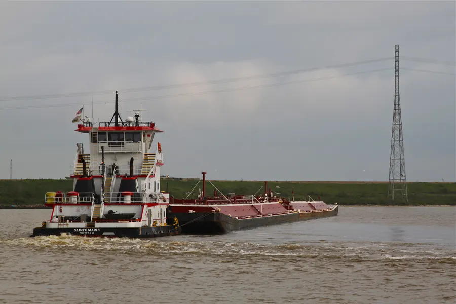 <i>Tugboats</i> memandu tongkang di Houston Ship Channel, alur pelayaran sempit dengan lalu lintas padat